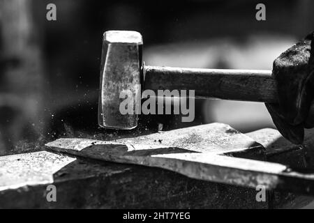 A Sword smith shaping a blade on an anvil Stock Photo