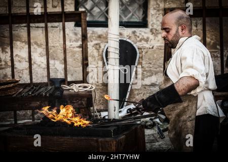 A Sword smith shaping a blade on an anvil Stock Photo