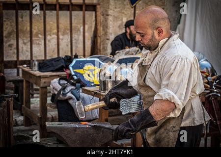 A Sword smith shaping a blade on an anvil Stock Photo