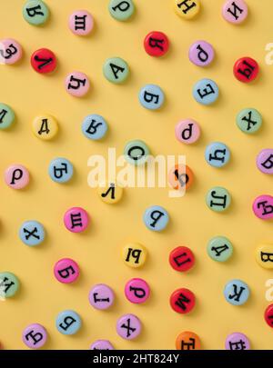 Cyrillic letters colorful buttons on a pastel yellow background. Russia, Eastern Europe minimal concept. Stock Photo