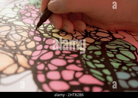 Hand is drawing wavy neurographic stripes. Multicolored abstraction Stock Photo