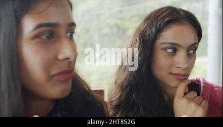 A couple of Indian young females seriously looking at something Stock Photo