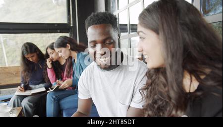 Smiling beautiful Indian woman talking to her male friend at a cafe Stock Photo