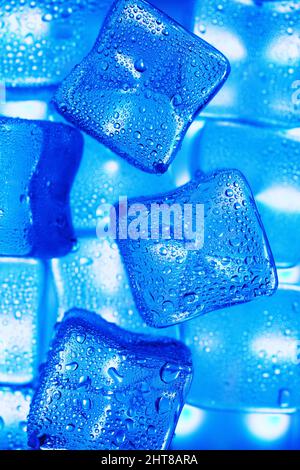 Ice cubes with blue backlight in the freezer close-up in full screen selective focus Stock Photo