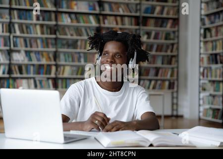 Happy motivated young African American guy looking in distance. Stock Photo