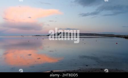 Sunset lights up clouds over the Isle of Portland on Dorset's Jurassic Coast. Stock Photo