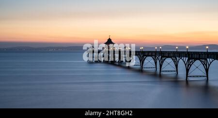 The sun sets over the Bristol Channel and South Wales at Clevedon Pier in Somerset, England. Stock Photo