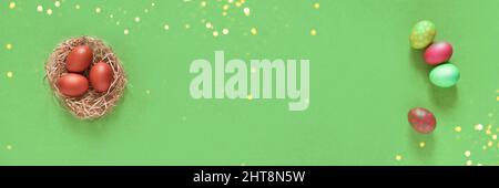 Banner with Easter eggs in a nest on a green background. Minimal concept. Top view. With a space to copy. High quality photo Stock Photo