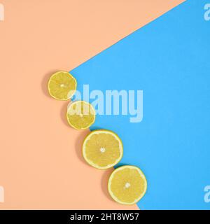 Fresh citrus fruits composition of sliced lemons on pastel beige and blue background. Flat lay organic food minimal Stock Photo