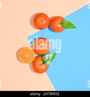 Summer fruit arrangement of oranges or tangerines on pastel beige and blue background. Flat lay concept Stock Photo