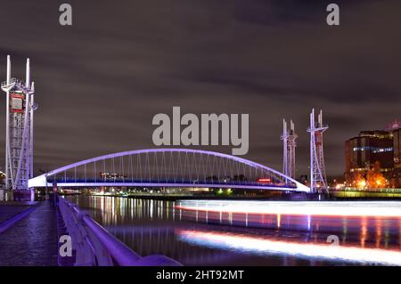 A long exposure of a moving boat on the river near the bridge in Salford Quays, UK Stock Photo