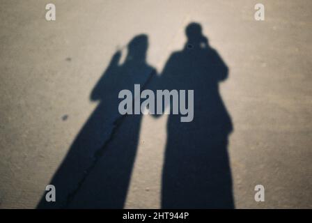 Beautiful shot of a shadow of a couple posing on a street Stock Photo