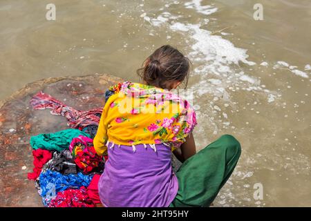 Woman washing laundry on the riverbank of Ganges River, Kolkata, West Bengal, India Stock Photo