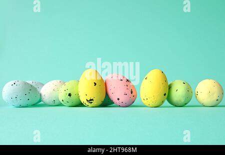 Row of painted colored easter eggs on blue background. Happy Easter background. Stock Photo
