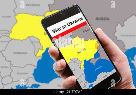 War in Ukraine on mobile phone screen. Ukraine and Russia borders with Donbass on Europe map. Ukrainian-Russian conflict in smartphone. Concept of med Stock Photo