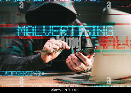 Malvertising - phone hack and attack method concept. Cyber criminal hacker using laptop and smartphone with glitch effect Stock Photo
