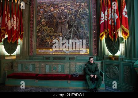 Moscow Region, Russia. 26th of February, 2022 A soldier seat on a background of a mosaic mural in the Resurrection of Christ Cathedral, the main Orthodox cathedral serving the Russian Armed Forces, encircled by the Road of Memory memorial in Patriot Military Park and commemorating the 75th anniversary of the victory of the Soviet Red Army over Nazi Germany in the 1941–1945 Great Patriotic War Stock Photo