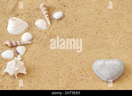 On the dog are different types of shells and a stone in the shape of a heart, which says Be Happy. There is a place for your notes - copyspace. Stock Photo