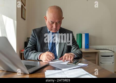 A senior executive signing a document in the office. Work, office concept. Stock Photo