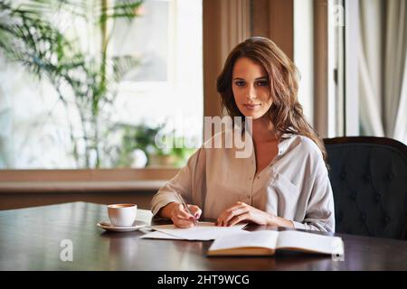 Shes preparing notes for her next novel. Portrait of an attractive young woman writing in a relaxed environment at home. Stock Photo