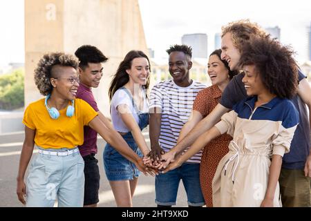 Group of young student friends with hands on stack showing international unity Stock Photo