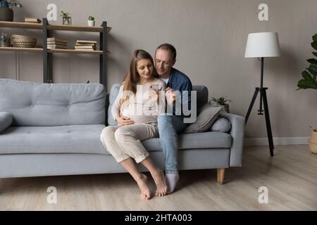 Happy young couple using virtual mobile service, online app Stock Photo