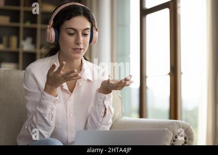 Concentrated beautiful young Hispanic woman holding video call conversation. Stock Photo