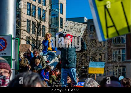 A little boy is holding a placard asking for boycott Russia, during the massive demonstration against Putin's invasion of Ukraine, organized in Amsterdam, on February 27th, 2022. After Putin's decision to attack Ukraine, several protests were organized in the center of the city, on the same day to show their support with the Ukrainian people. The Ukrainian community, the Russian community, and several non-governmental organizations in The Netherlands accompanied by thousands of people gathered at the Dam square to protest against Putin and the war in Ukraine.(Photo by Romy Fernandez/Sipa USA) Stock Photo