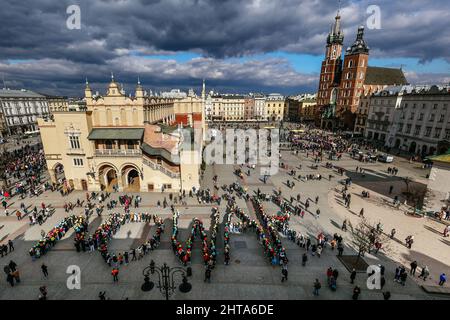 Krakow, Poland. 27th Feb, 2022. A group of Italian students formed a colorful 'no war' sign at the Main Market Square during the demonstration. An anti-war protest by the Ukrainian community, the Poles and Belarusians who support them. Since the beginning of the Russian invasion of Ukraine, demonstrations have taken place daily and lasted many hours. Participants are constantly trying to reach as many people as possible with their message, including employees of the US and German consulates, in front of which they also stop several times a day. Credit: SOPA Images Limited/Alamy Live News Stock Photo