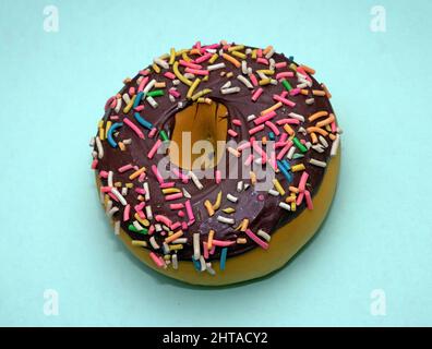 Chocolate glazed donut sweet dessert isolated on blue background Stock Photo