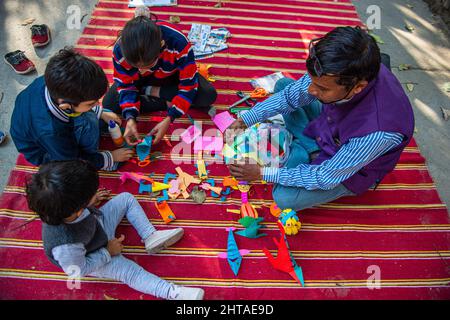 New Delhi, India. 27th Feb, 2022. Children learn to make paper toys during Sunday Market organized by Bikaner House Management Society in New Delhi. Delhi government lifted all COVID-19 restrictions on February 26 2022 in view of the declining number of coronavirus infections. Credit: SOPA Images Limited/Alamy Live News Stock Photo