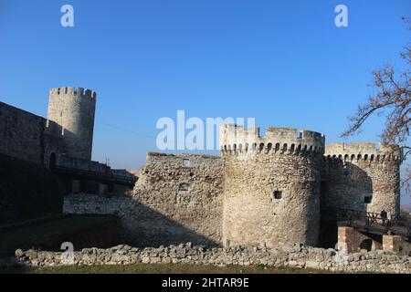 Ruins of an ancient castle with round towers and grey stone against a blue sky Stock Photo