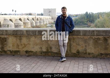 Cheerful young White guy posing on a bridge dressed casually Stock Photo
