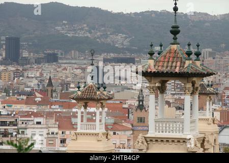 The towers in Placa de Les Cascades, Barcelona with cityscape and mountains in the background. Stock Photo