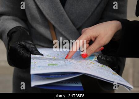 Closeup shot of a woman showing something on the map Stock Photo