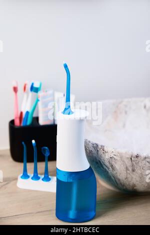 Blue home oral irrigator kit in bathroom, Waterpik for teeth cleaning, portable water flosser for dental care Stock Photo