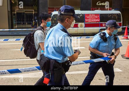 Hong Kong, China. 27th Feb, 2022. Police officers set a cordon during an operation against people who fail to comply with social distancing measures in Central district in Hong Kong. Hong Kong is tightening rules of social distancing to counter the worst epidemic wave, imposing to wearing of masks outside in all circumstances and gatherings limited to two people. Credit: SOPA Images Limited/Alamy Live News Stock Photo