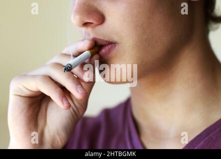 How to quit now.... Closeup of a person taking a drag from a cigarette. Stock Photo