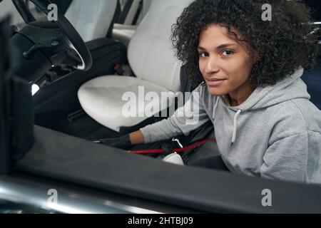Young detailer posing for camera during interior car detailing Stock Photo