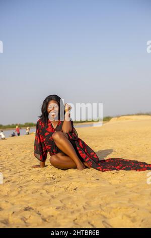 An attractive young African woman smiling and posing on the beach Stock Photo