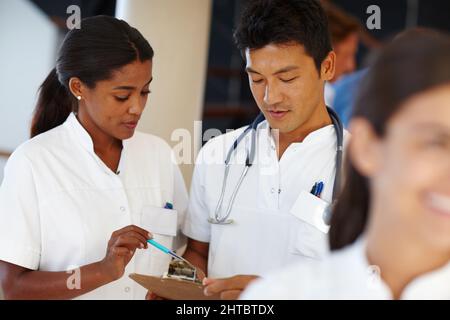 I can give you a few tips on this treatment. Shot of two medical professionals discussing a document. Stock Photo