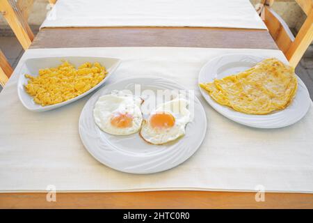 Various ways to cook chicken eggs. Boiled omelet, scrambled eggs and fried omelet. Close-up. Stock Photo