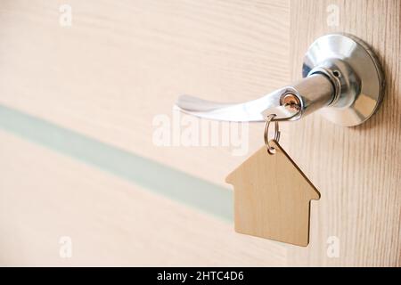 Key with keychain in form house in door lock.With bright sunlight Stock Photo