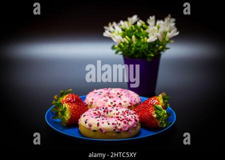 delicious donuts and strawberries on a plate Stock Photo