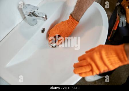 Male plumber hands repairing sink in bathroom Stock Photo