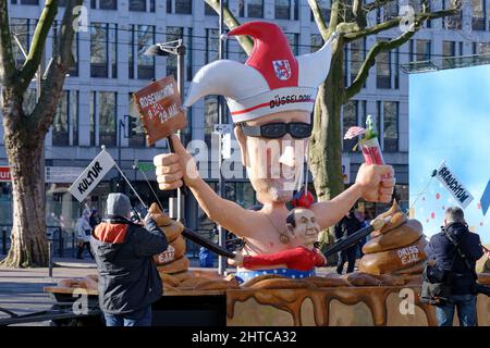 Cologne, Germany. 28th Feb, 2022. A persiflage float shows the president of the Comitee Düsseldorf Carneval, M. Laumen and the float builder J. Tilly before the peace demonstration on Rose Monday at Neumarkt. In Düsseldorf, the Shrove Monday procession is to take place in May. After the Russian attack on Ukraine, the Rose Monday festival was canceled, and instead a protest march moves through the city center - past many of the motif floats that were actually built for the Rose Monday procession. Credit: Henning Kaiser/dpa/Alamy Live News Stock Photo