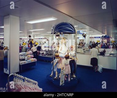 Queensgate Centre, Peterborough, Cambridgeshire, 19/04/1982. An interior view of British Home Stores within Queensgate Shopping Centre, showing clothing displayed on mannequins. The contract for the Queensgate Centre, located in the heart of Peterborough, was awarded to Laing in 1975. Various planning enquiries and design changes delayed the start of the work however the inauguration ceremony finally took place in April 1978. The multi-level shopping centre was designed with a large car park and a new bus station, and many well-known retailers such as John Lewis, British Home Stores and Little Stock Photo