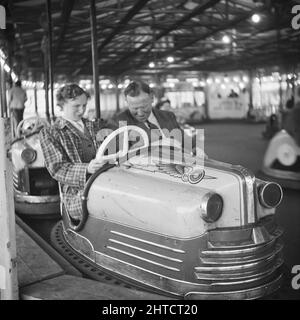 Whitley Bay, North Tyneside, 13/06/1953. A couple driving in a dodgem car during a Laing staff outing to Whitley Bay. In 1947, after a seven year break, Laing had resurrected their 'Area Outings' for staff and their families, with trips taking place in May and June. This trip was for their staff from the Carlisle area. Stock Photo