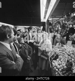 Wood Green Shopping City, Haringey, London, 08/02/1979. Actress Mollie Sugden amongst a crowd of customers at a fruit stall inside the newly opened Market Hall at Wood Green Shopping City. The Market Hall at Wood Green Shopping City was opened on 8th February 1979. Actress Mollie Sugden, who famously portrayed Mrs Slocombe in British sitcom 'Are you being served?', visited various stalls in the new two-storey market hall on its opening day. Stock Photo