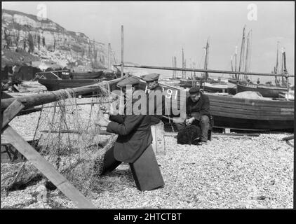 Fishermen mending nets on the beach, Hastings, East Sussex, 1925-1939. Stock Photo